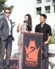 Kristen Stewart speak to the fans, while Robert Pattinson and Taylor Lautner listen at the TWILIGHT TRIO HANDPRINT AND FOOTPRINT CEREMONY | ©2011 Sue Schneider