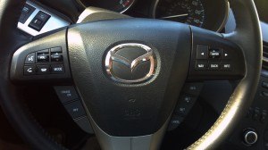 ASSIGNMENT X view of the steering wheel on the 2012 MAZDA3 FOUR-DOOR | ©2012 Assignment X