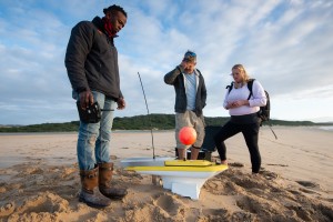 The team gets ready for color testing with a remote control boat in CAMO SHARKS | ©2022 National Geographic/Fiona Ayerst